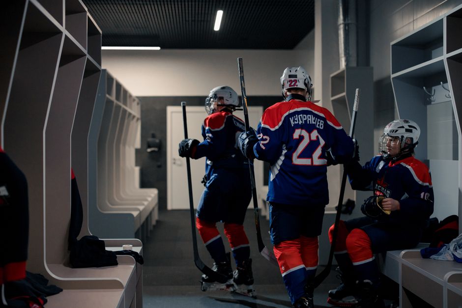 A team of hockey players getting ready in the locker room before the game.